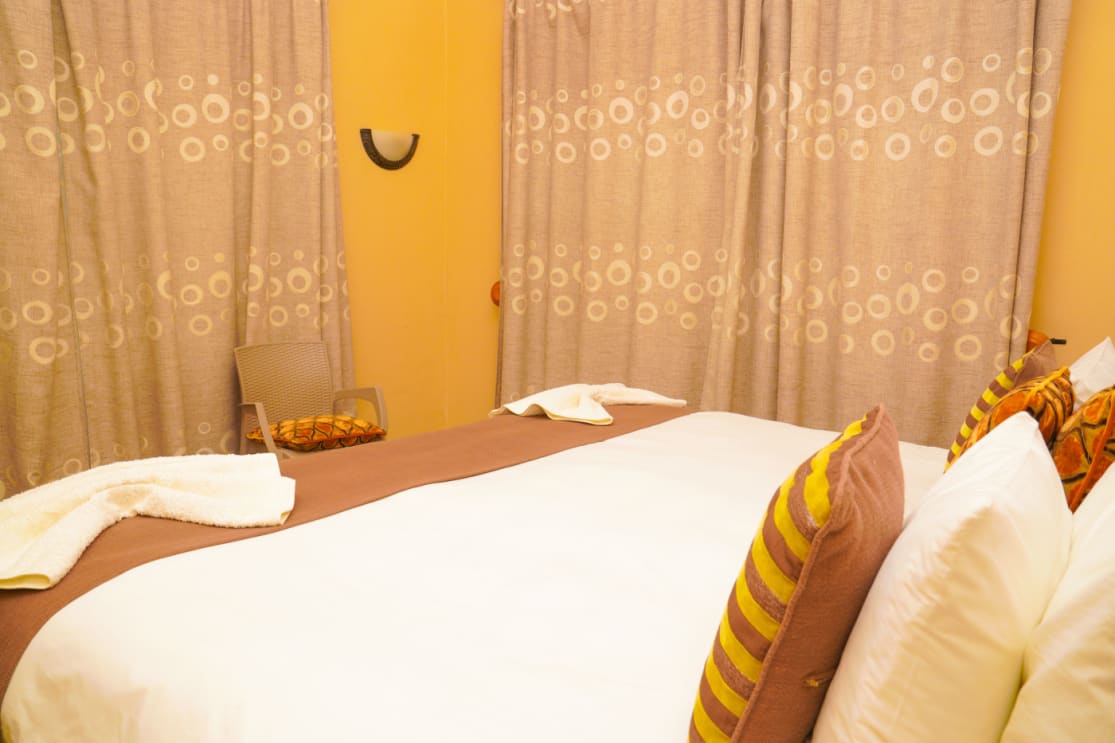 Guest room with a double bed and patterned cushions