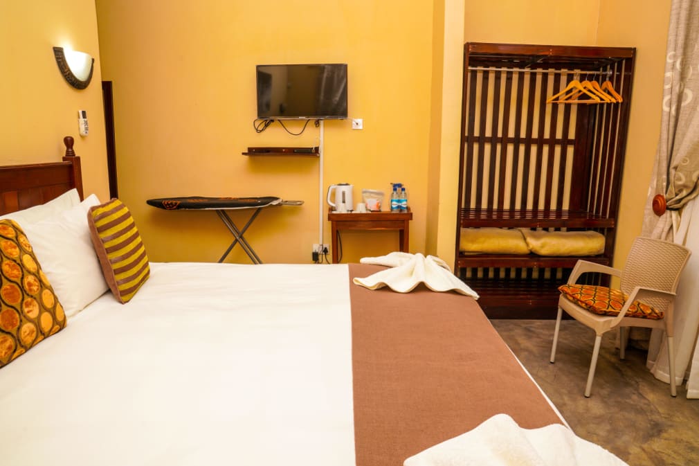 Guest room with a double bed, TV, kettle and wardrobe