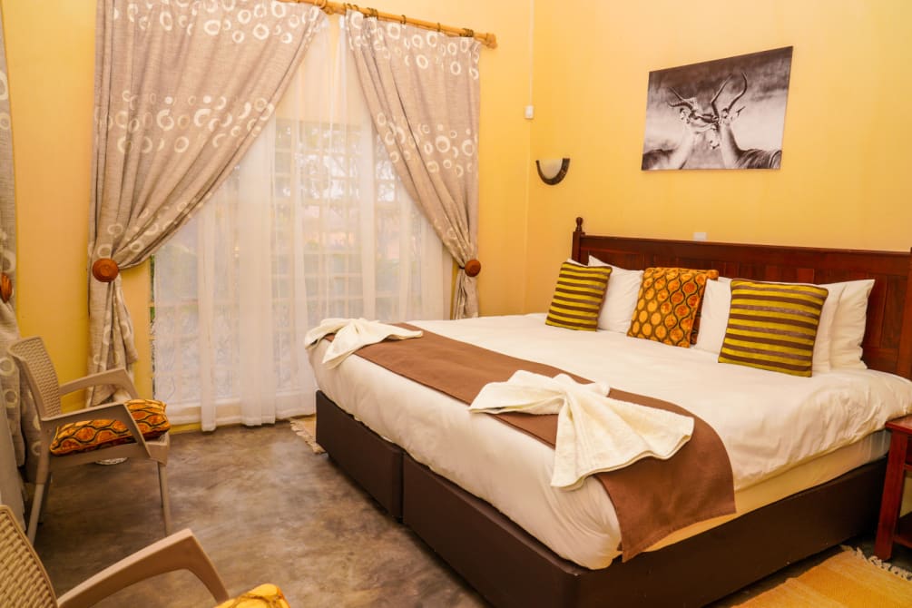Guest room with a double bed, armchair and wildlife print