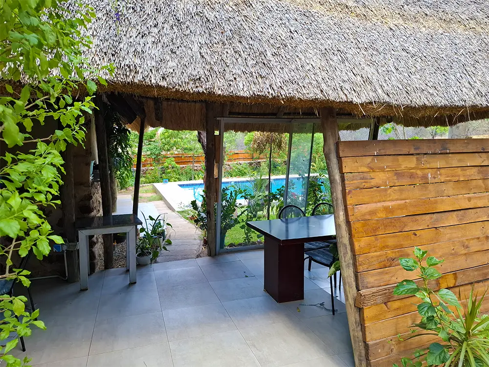 Thatched lapa with a dining table looking out to the pool