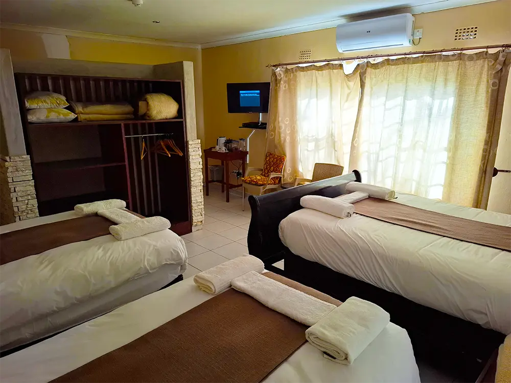 Room with three beds and a wardrobe