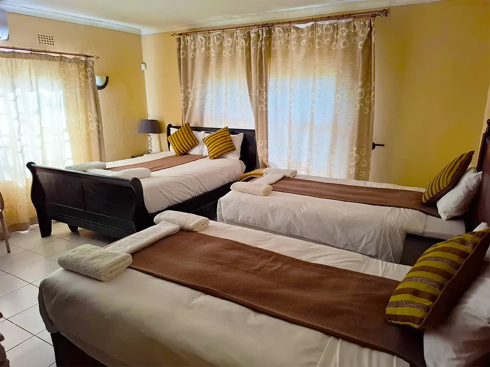 Room with three beds and a TV